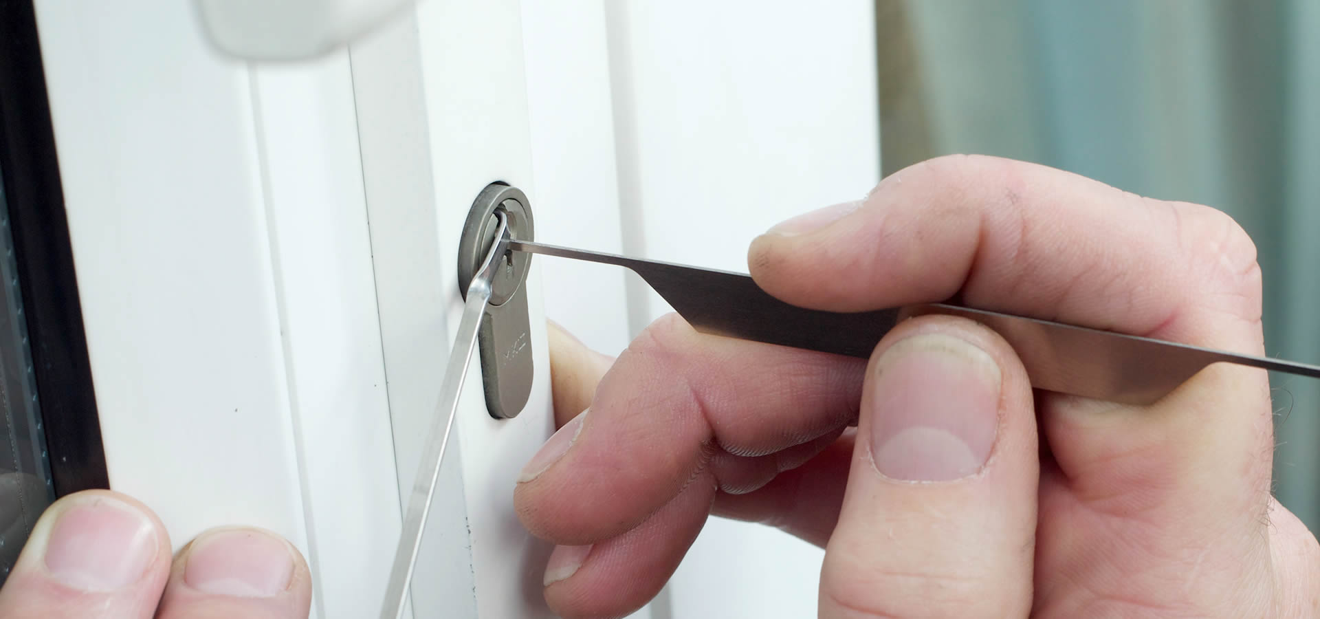 Hand using lockpick tool inserted into modern lock